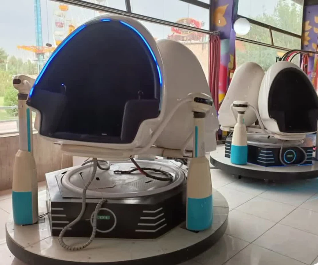 Two egg-shaped 9D virtual-reality motion chairs on their rotating platforms at an indoor amusement park