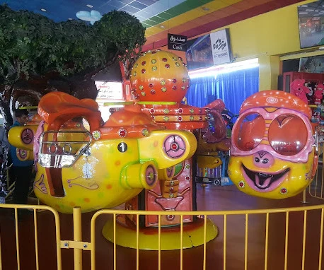 A brightly coloured children's spinning ride beside a toy shop inside the Rangeen Koman complex