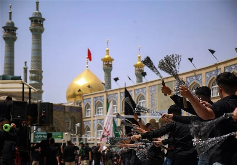Young men performing zanjeer-zani (chain matam) during Ashura in front of the golden dome of the Lady Masumah (a) shrine in Qum, black mourning flags flying