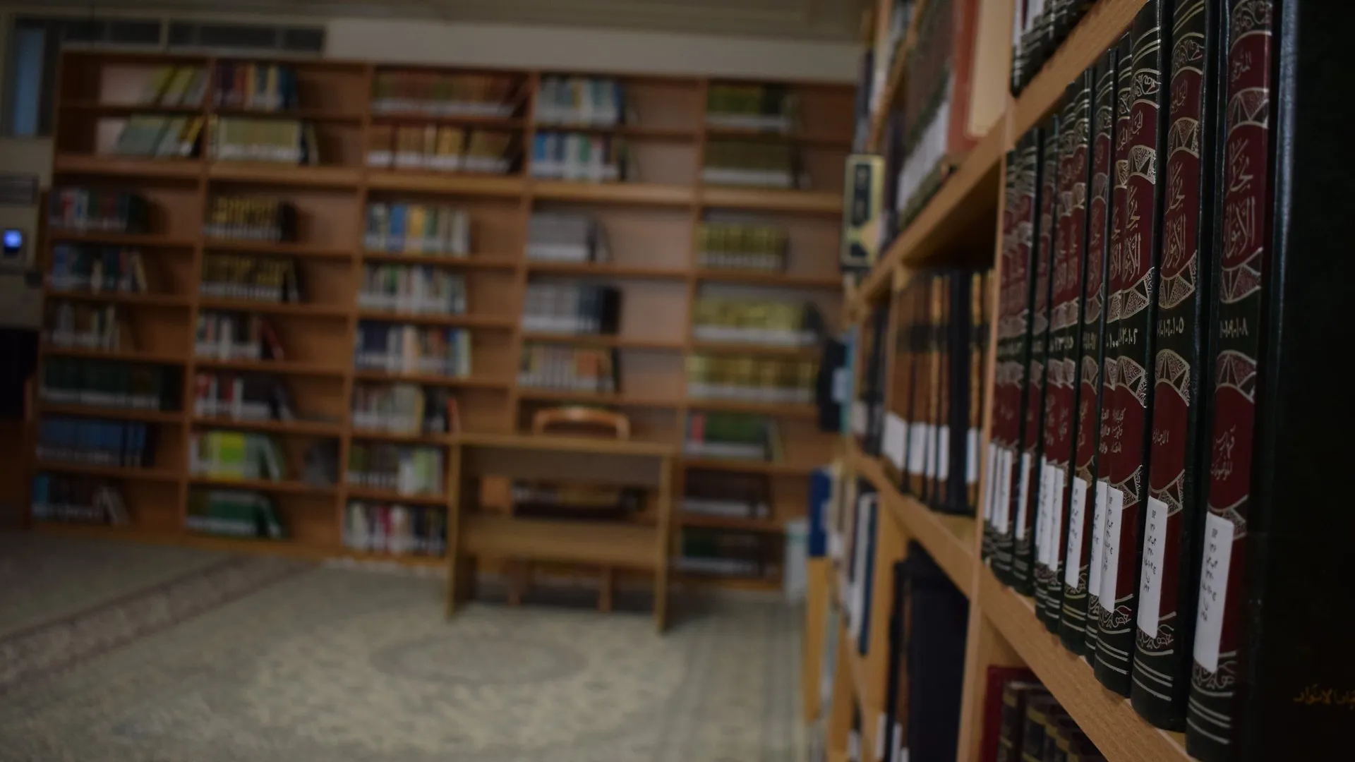 Reading room of a hawzah library in Qum, with tall wooden shelves of bound Islamic texts and a study table