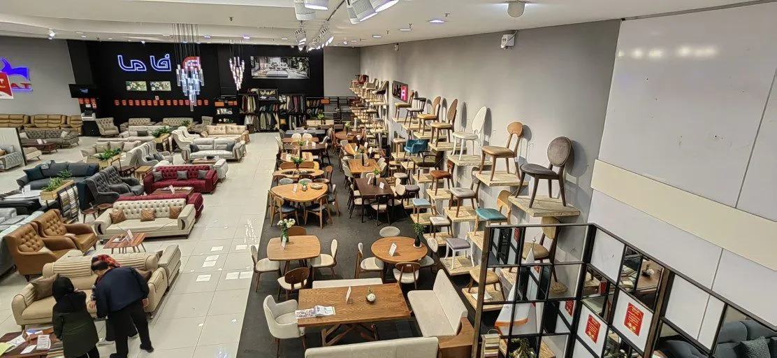 A large furniture showroom in Qum displaying rows of sofas, dining tables and chairs