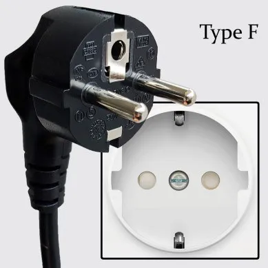 A black Type F plug with two round pins and side earth clips beside a matching white round wall socket