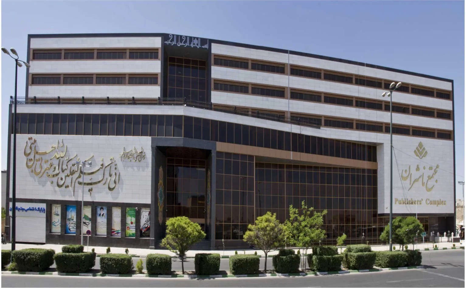 Exterior of the seven-storey Publishers' Complex building in Qum, a stone-and-glass commercial building with Arabic calligraphy on its façade